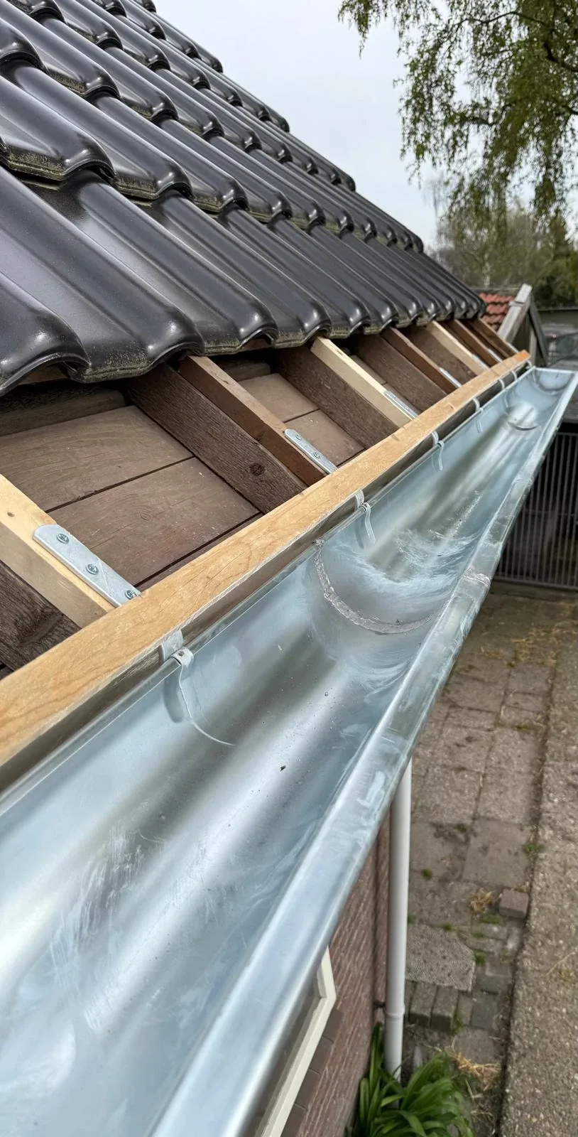 Nieuwe zinken dakgoot over de volle lengte van het dak